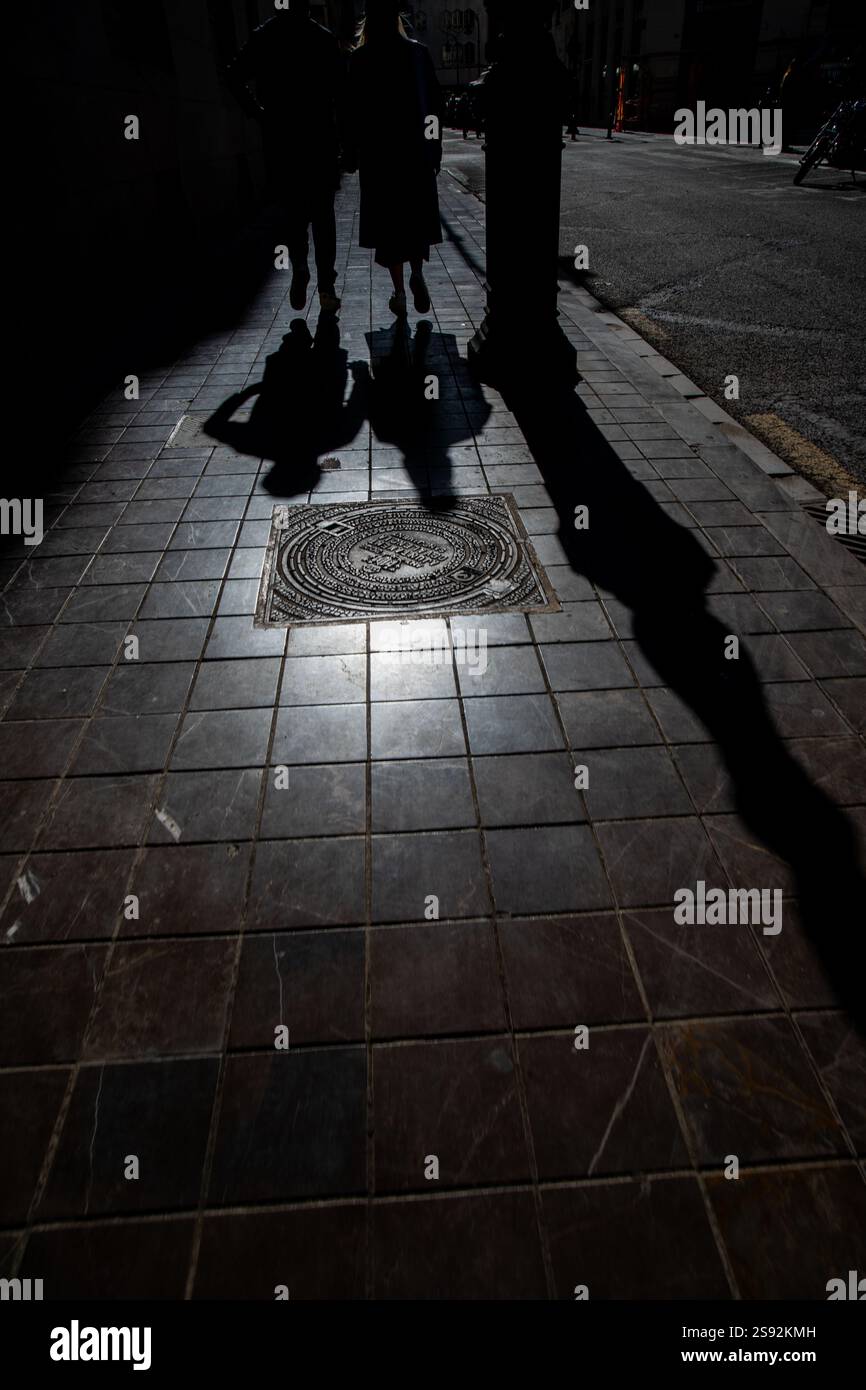 Ombre di due persone che camminano per terra. Foto Stock