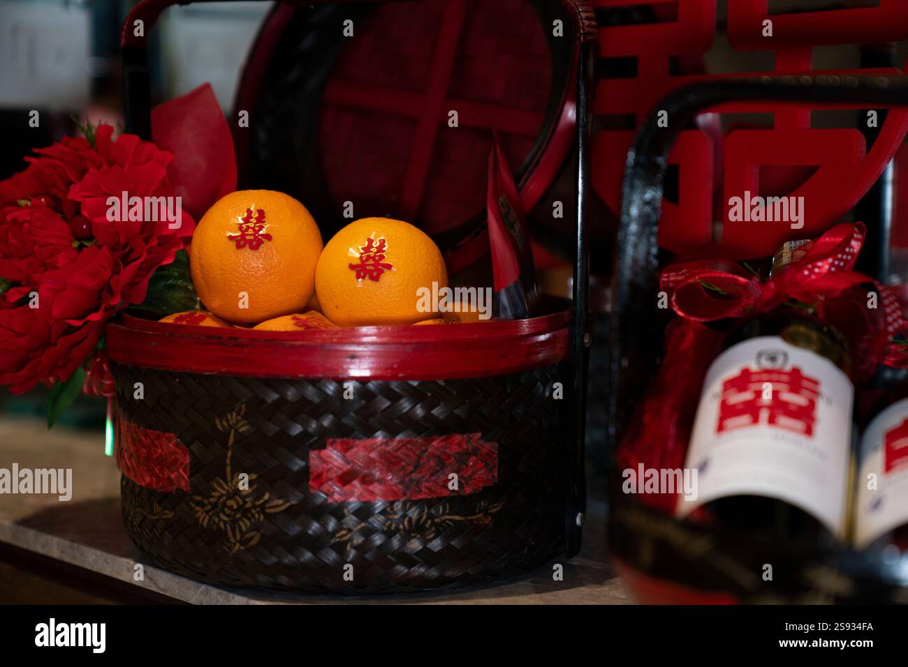 Cesti contenenti regali di nozze (bottiglie, arance e decorazioni rosse). Foto Stock