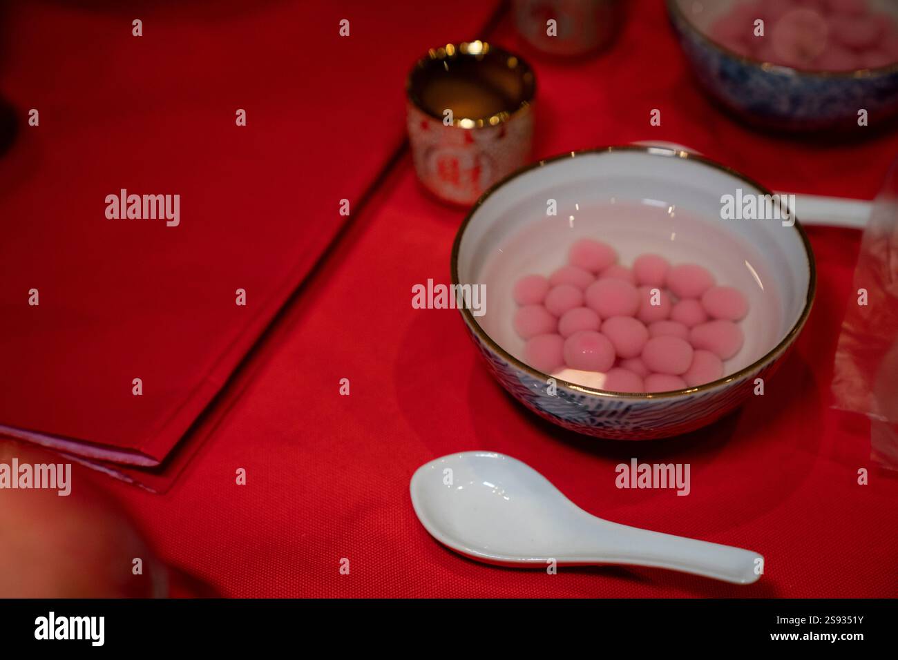 Tangyuan rosa (palline di riso glutinoso) servito su un panno rosso Foto Stock