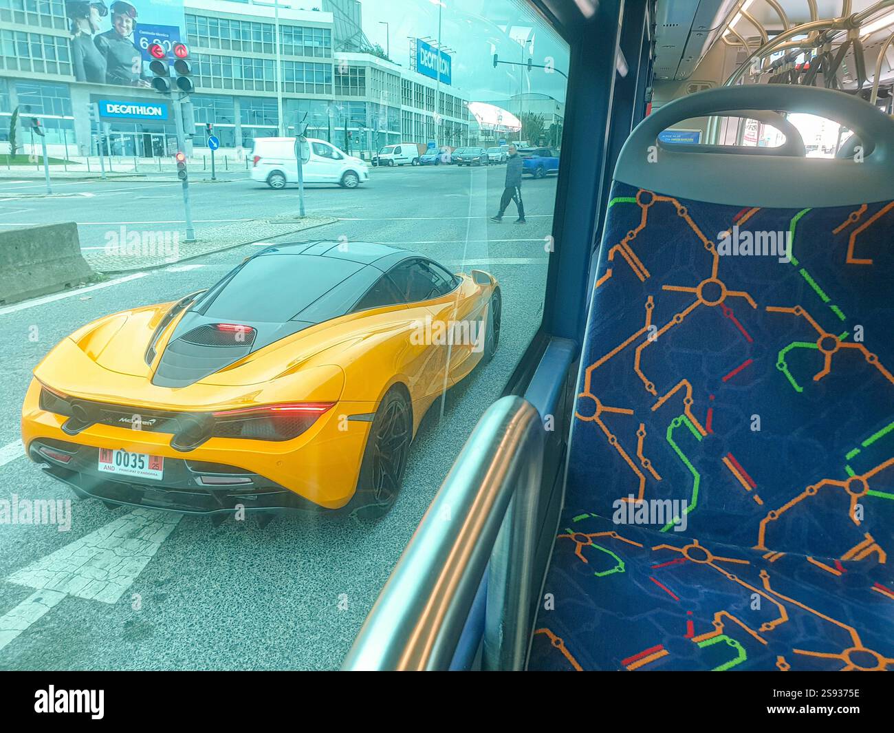 L'auto gialla McLaren con registrazione dal principato di Andorra si fermò a un semaforo catturato dall'interno di un autobus di trasporto pubblico a Lisbona Foto Stock