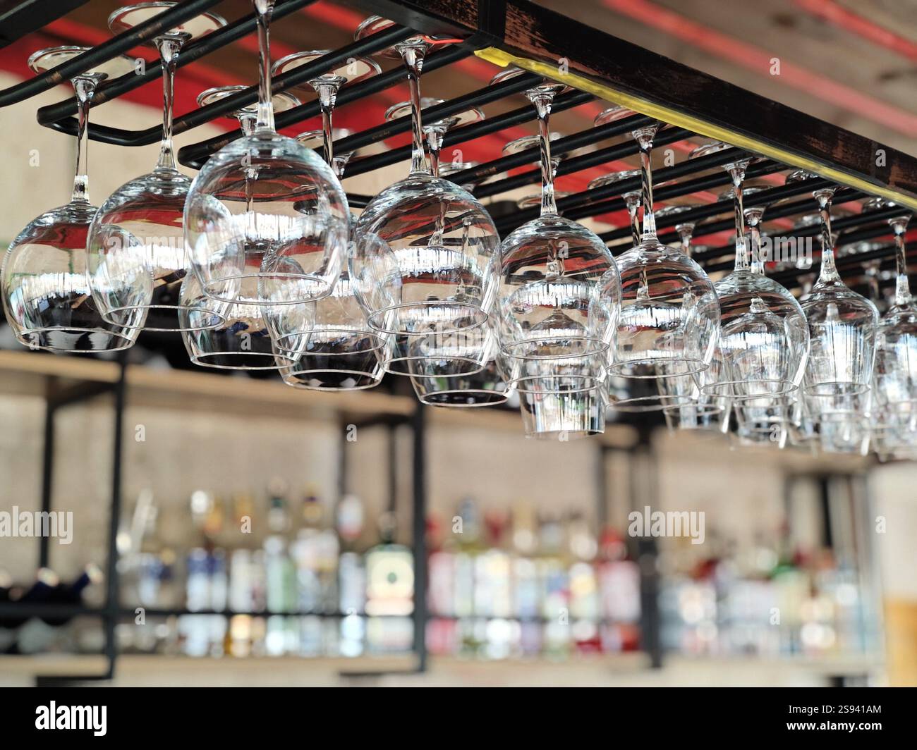 Goreme, Cappadocia, Turchia - 23 novembre 2024 : file di bicchieri da vino appesi a testa in giù su scaffali metallici in un bar Foto Stock