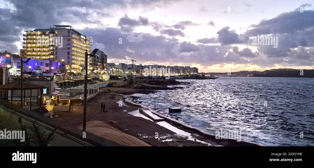 Bugibba. Malta. Lungomare di Qawra, parte della baia di St. Paul, di fronte alla baia di St. Paul in prima serata. Foto Stock