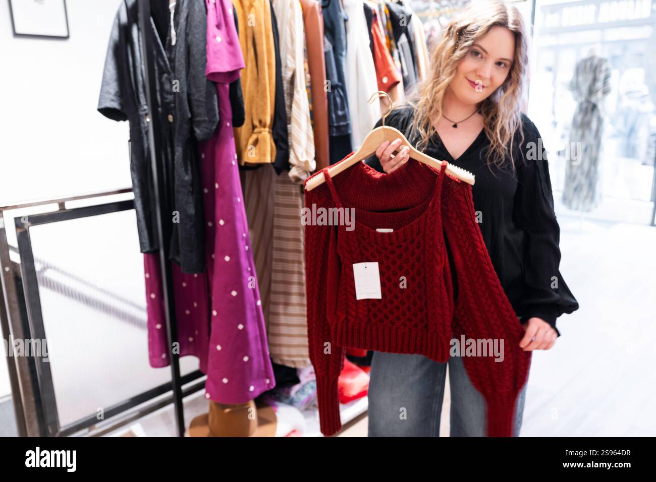 Il turista biondo acquista un maglione rosso disegnato da uno stilista del marchio Koshka all'interno del suo atelier, Parigi, Francia Foto Stock