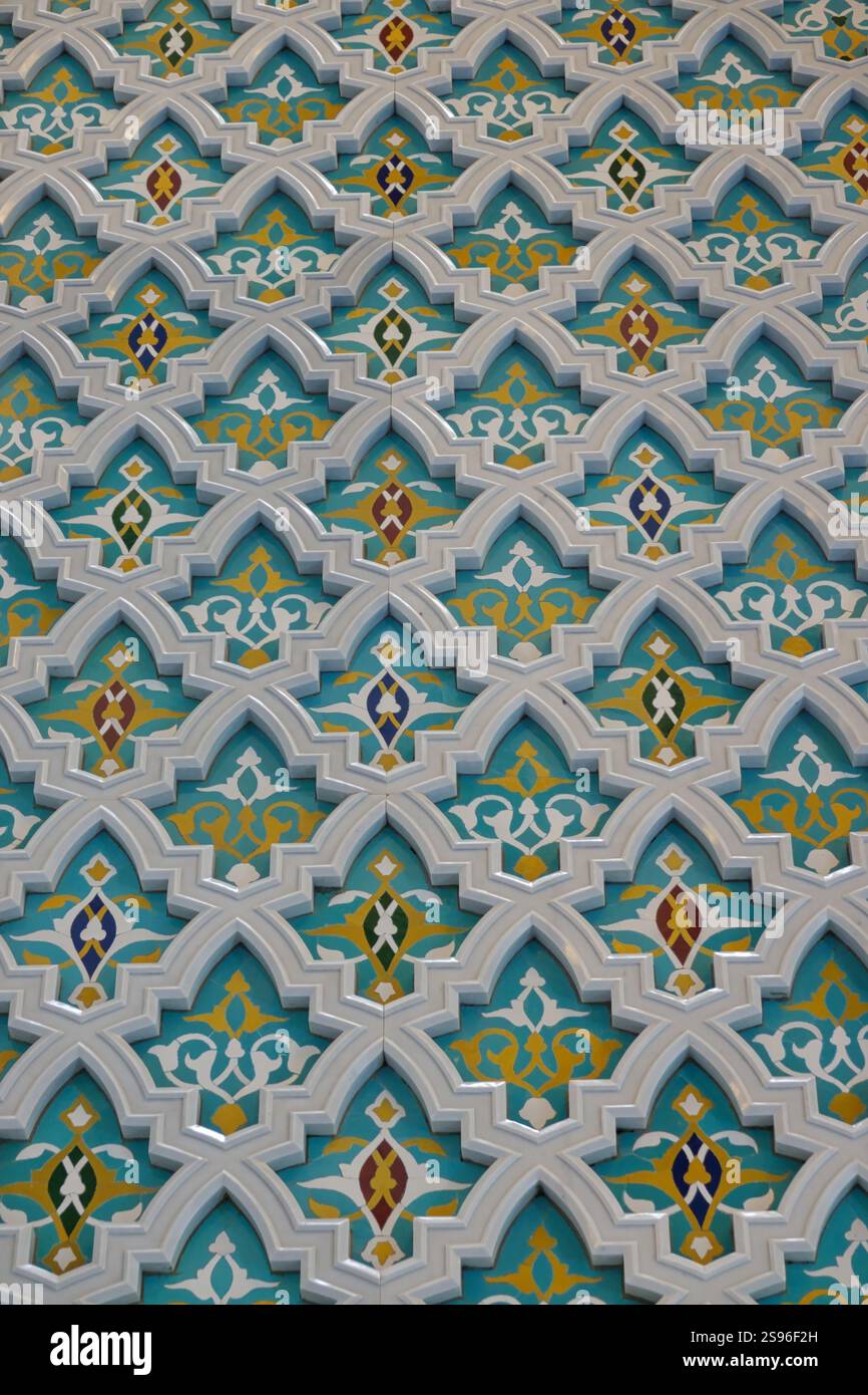 Dettaglio delle decorazioni in marmo bianco in rilievo su sfondo blu con decorazioni floreali all'interno della grande moschea del Sultano Qaboos. Foto Stock