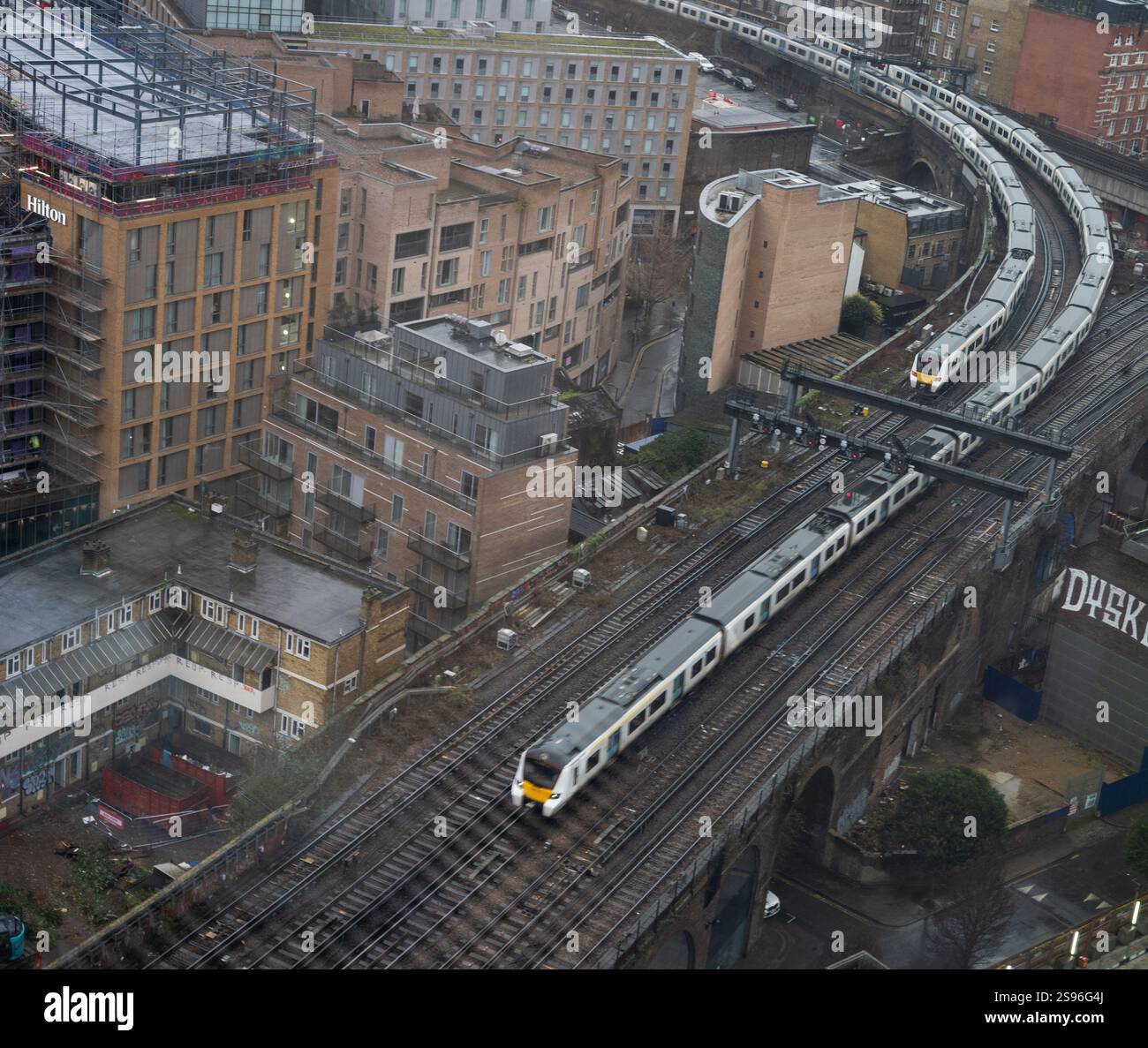 Vista aerea di due treni che viaggiano nella stessa direzione su binari sopraelevati nella città di Londra. Foto Stock