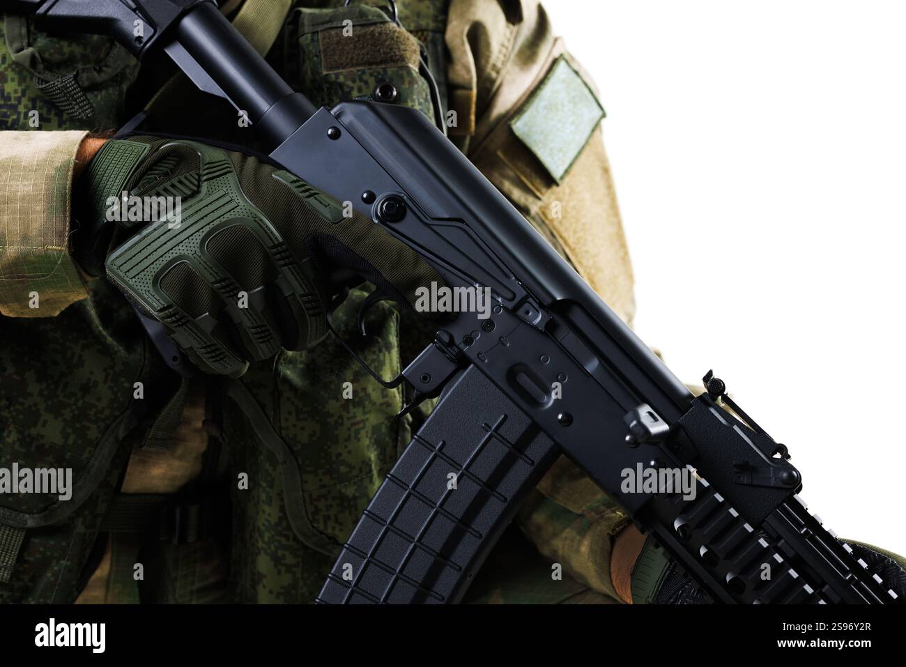 Primo piano di un militare che tiene in mano un fucile indossando guanti tattici verdi, enfatizzando la difesa e la prontezza al combattimento. Perfetto per la tattica, Foto Stock