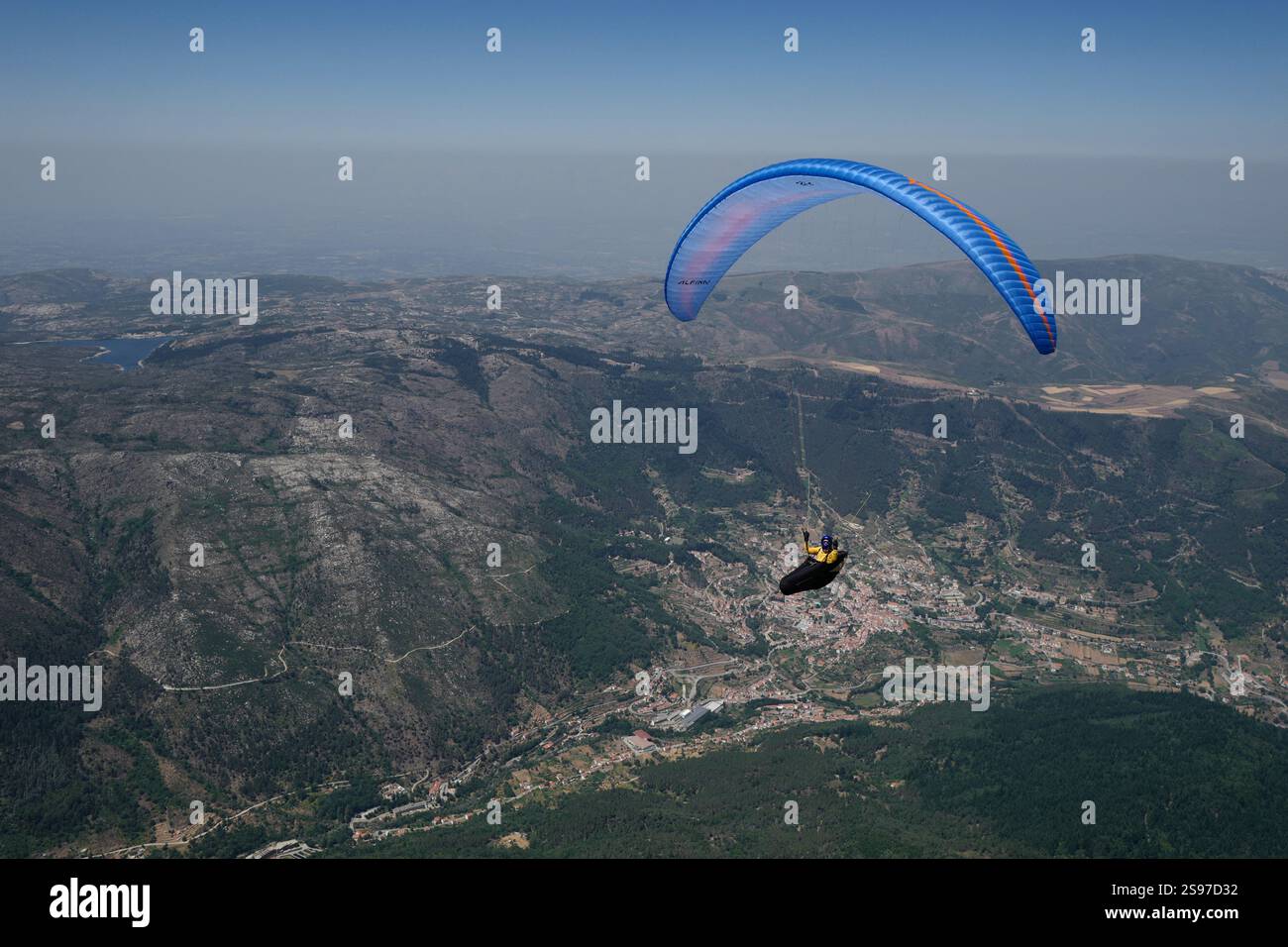 Un parapendio in volo a Serra da Estrela con Manteigas sullo sfondo. Foto Stock