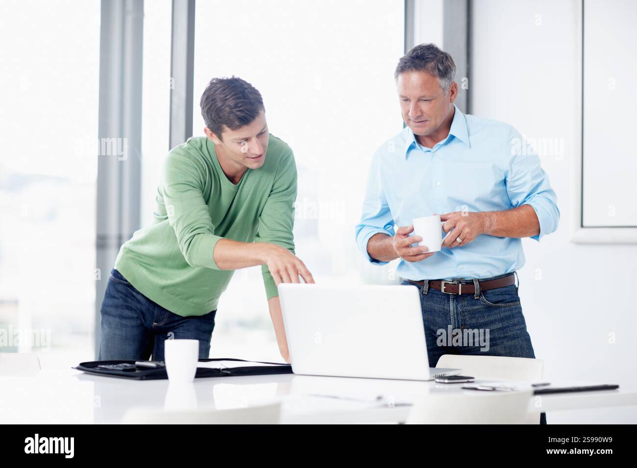 Uomini d'affari, mentore o punta al notebook durante una riunione per feedback sul budget, ricerche o supporto. Consulenza professionale, responsabile acquisti o. Foto Stock