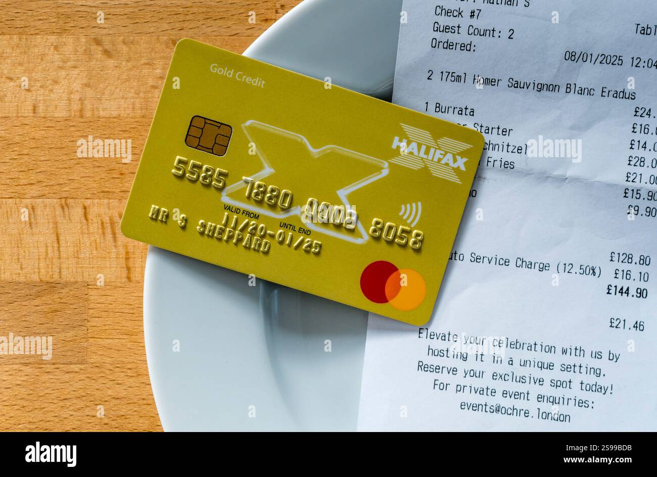 Carta di credito con conto su un piattino per pagare un pasto in un ristorante. Foto Stock