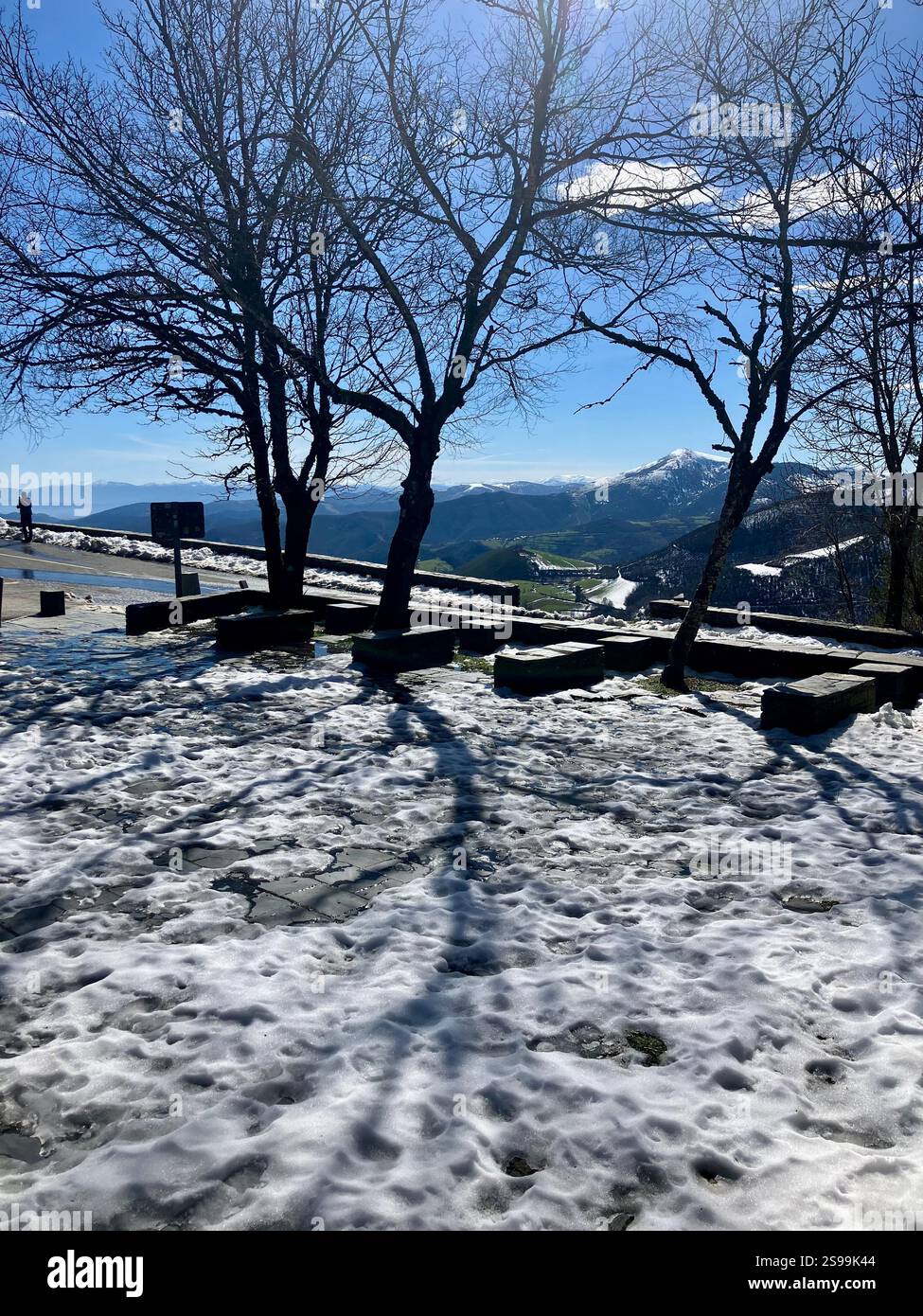 Vista sulle montagne con cielo azzurro, neve e alberi: O Cebreiro, Galizia Foto Stock