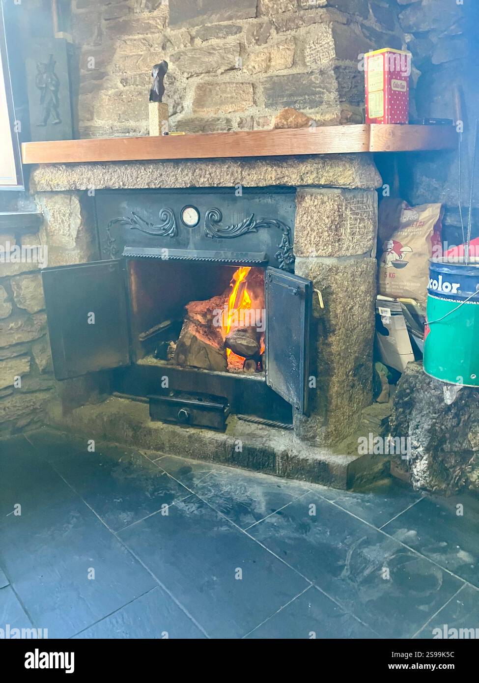 Ruggente fuoco in un fuochi a legna in Stone Surround; bar tradizionale nel nord della Spagna - Immagine stock catturata con smartphone