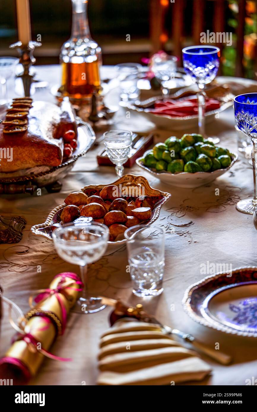 Tavolo da pranzo festivo con piatti eleganti, bicchieri di cristallo e decorazioni stagionali Foto Stock