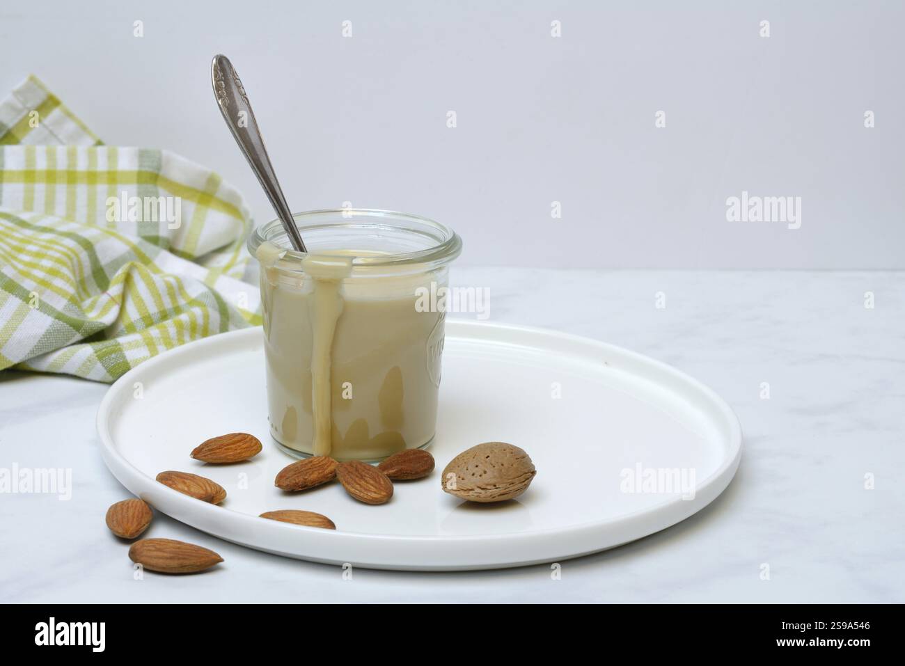 Crema di mandorle in vaso e mandorle Foto Stock