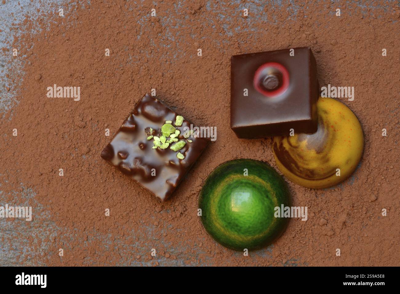 Cioccolatini colorati su cacao in polvere Foto Stock