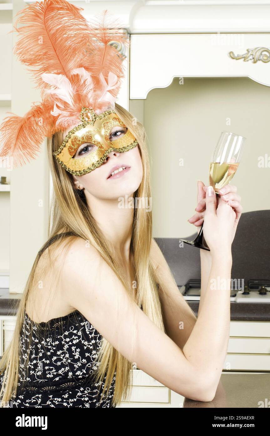 Donna all'interno. Bella bionda in una maschera veneziana Foto Stock