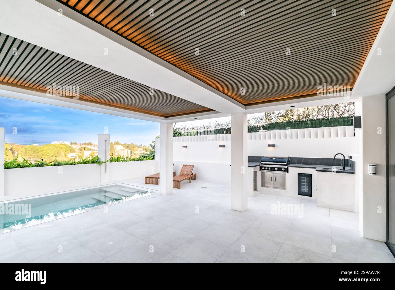 un'immagine di un giardino di ville mediterranee con piscina privata e cucina esterna Foto Stock