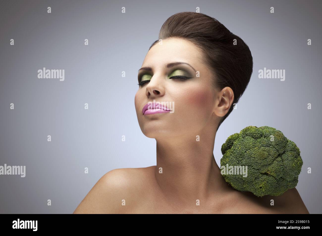 La dolce foto della bellezza con i broccoli sulla spalla Foto Stock