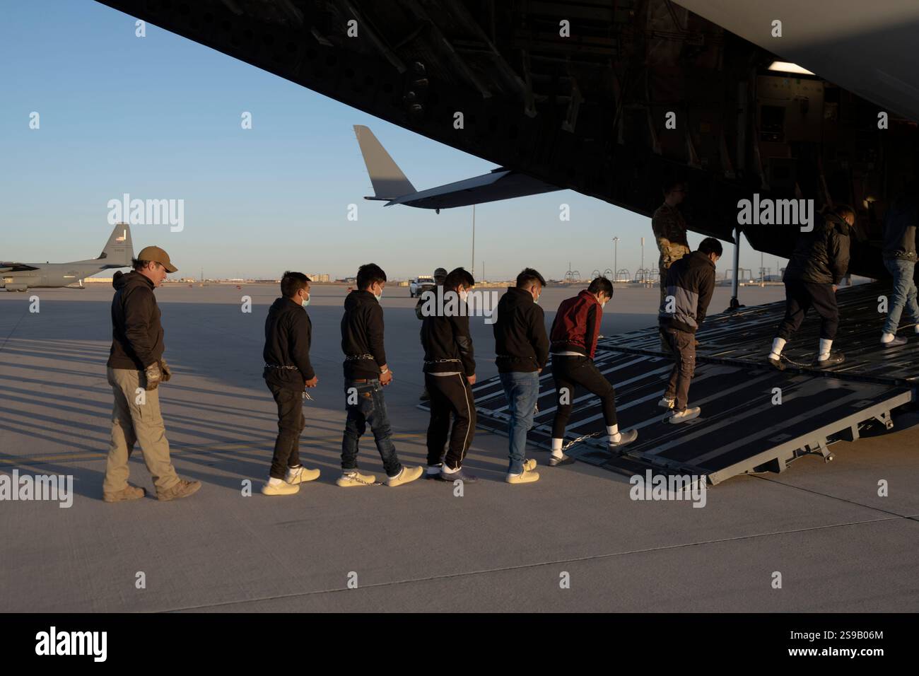 El Paso, Stati Uniti. 23 gennaio 2025. Gli agenti delle dogane e della protezione delle frontiere degli Stati Uniti guidano i migranti non documentati verso una U. C-17 Globemaster III della S Air Force trasportava aerei per il primo volo di rimozione in Guatemala da Fort Bliss, 23 gennaio 2025 a El Paso, Texas. I voli di rimozione erano diretti dal presidente Donald Trump ed è la prima volta che gli aerei militari sono stati utilizzati per i voli di deportazione. Crediti: Sergente 1C Nicholas De la pena/U. S Army Photo/Alamy Live News Foto Stock