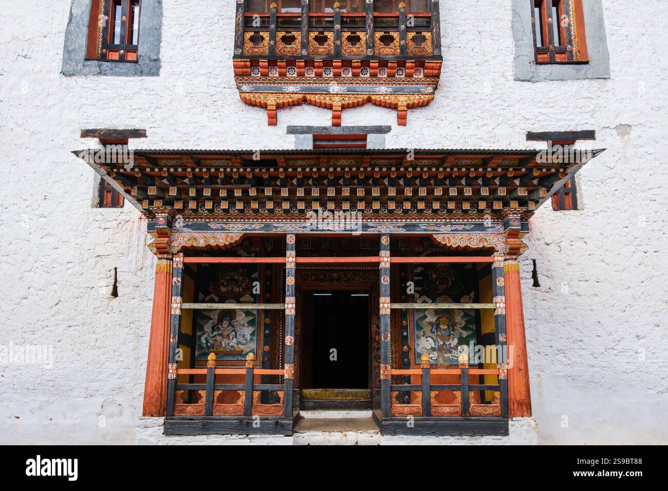 Pareti dipinte di bianco e decorazioni colorate e ornate a Paro Dzong, Bhutan Foto Stock