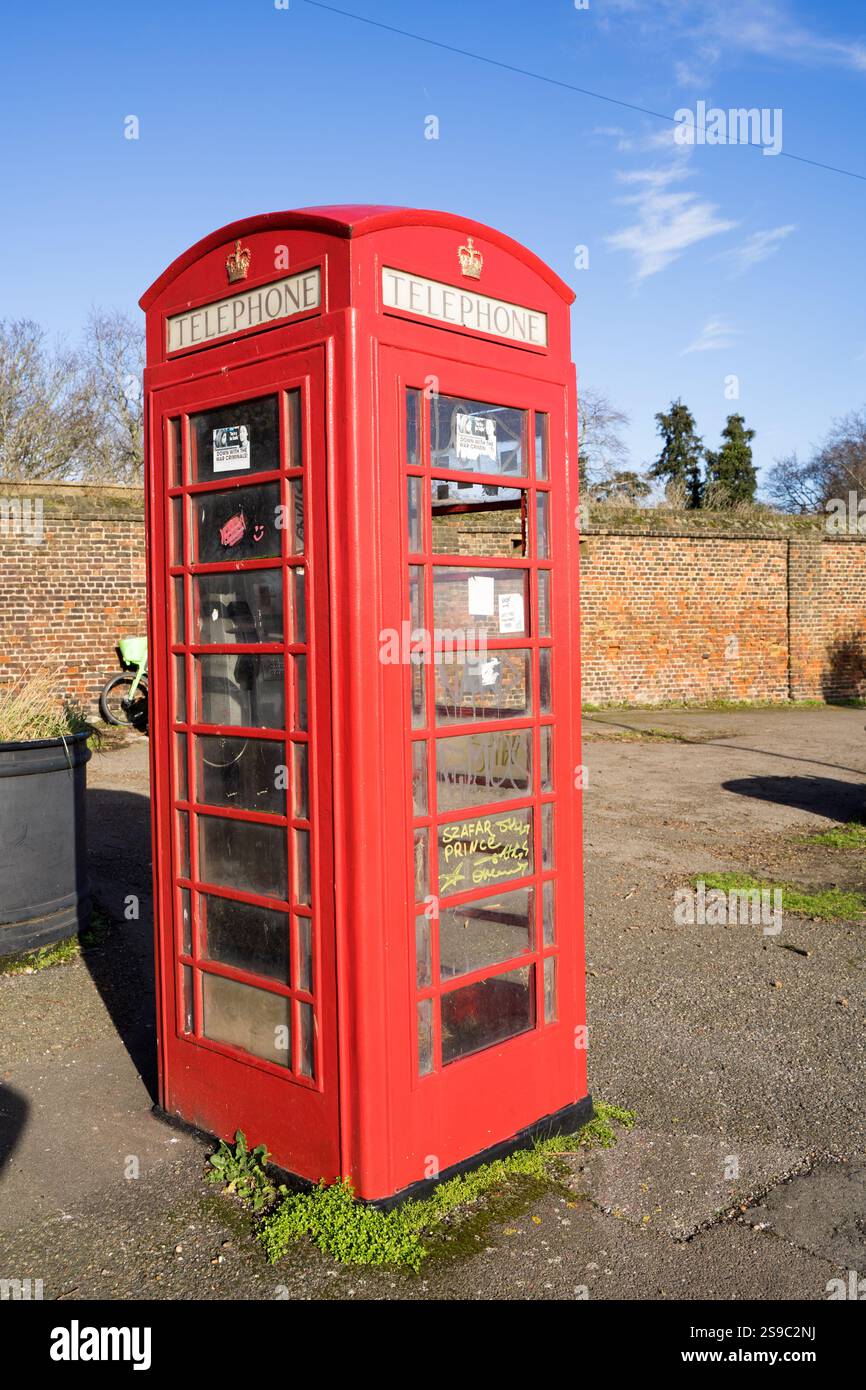 Red BT, telefono britannico fuori uso fuori dal muro di mattoni di Greenwich Park Foto Stock