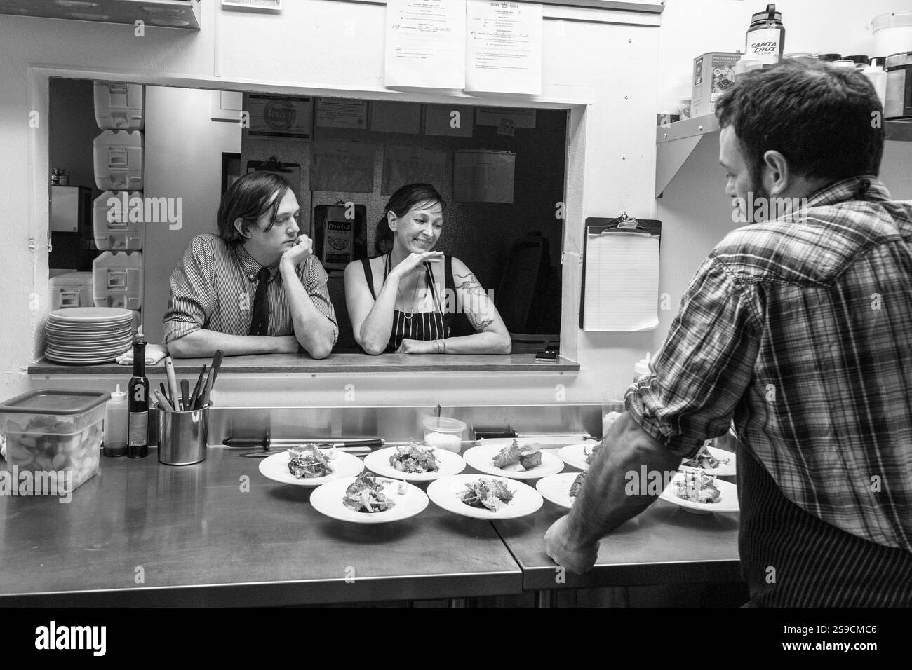 Lo chef in cucina parla della preparazione dei pasti in bianco e nero professionale, Fog Lark Foto Stock
