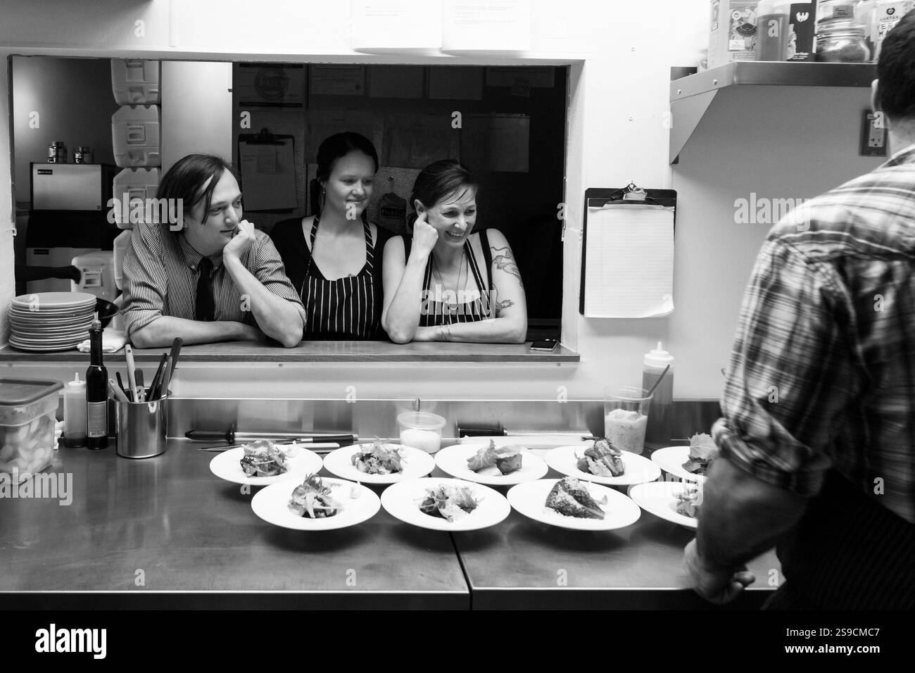 Lo chef in cucina parla della preparazione dei pasti in bianco e nero professionale, Fog Lark Foto Stock