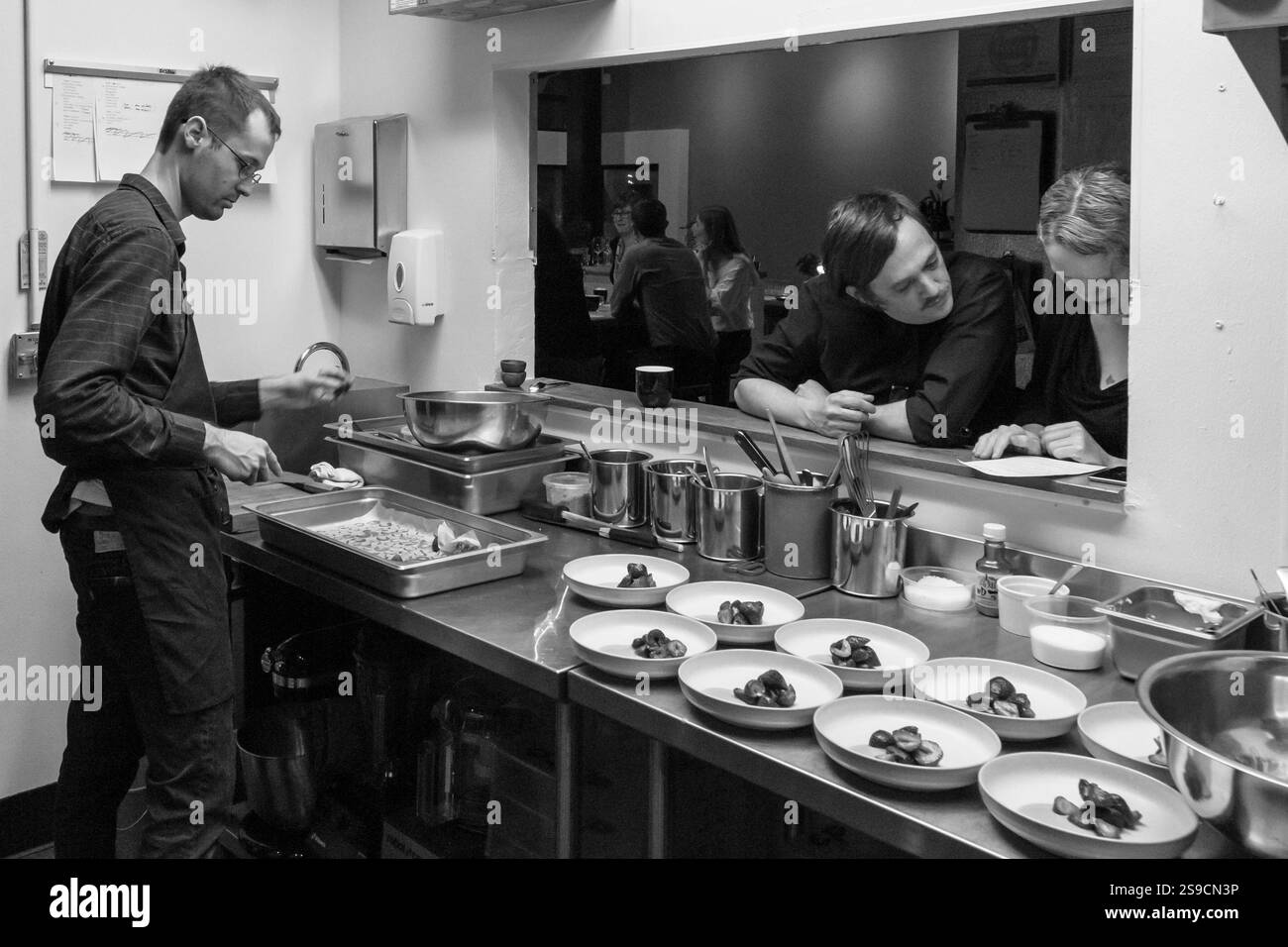 Il team della cucina commerciale prepara piatti e socializza in un ristorante, Fog Lark Foto Stock