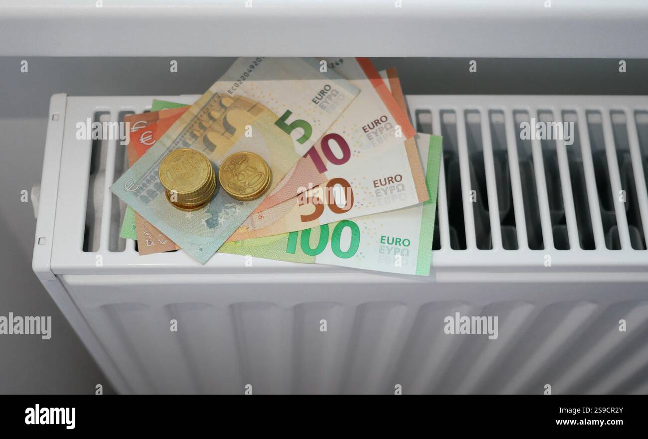 Soldi sulla batteria del radiatore di riscaldamento. Banconote in euro su termostato. Il concetto di aumento dei prezzi del gas e del riscaldamento, prezzi costosi per le bollette Foto Stock