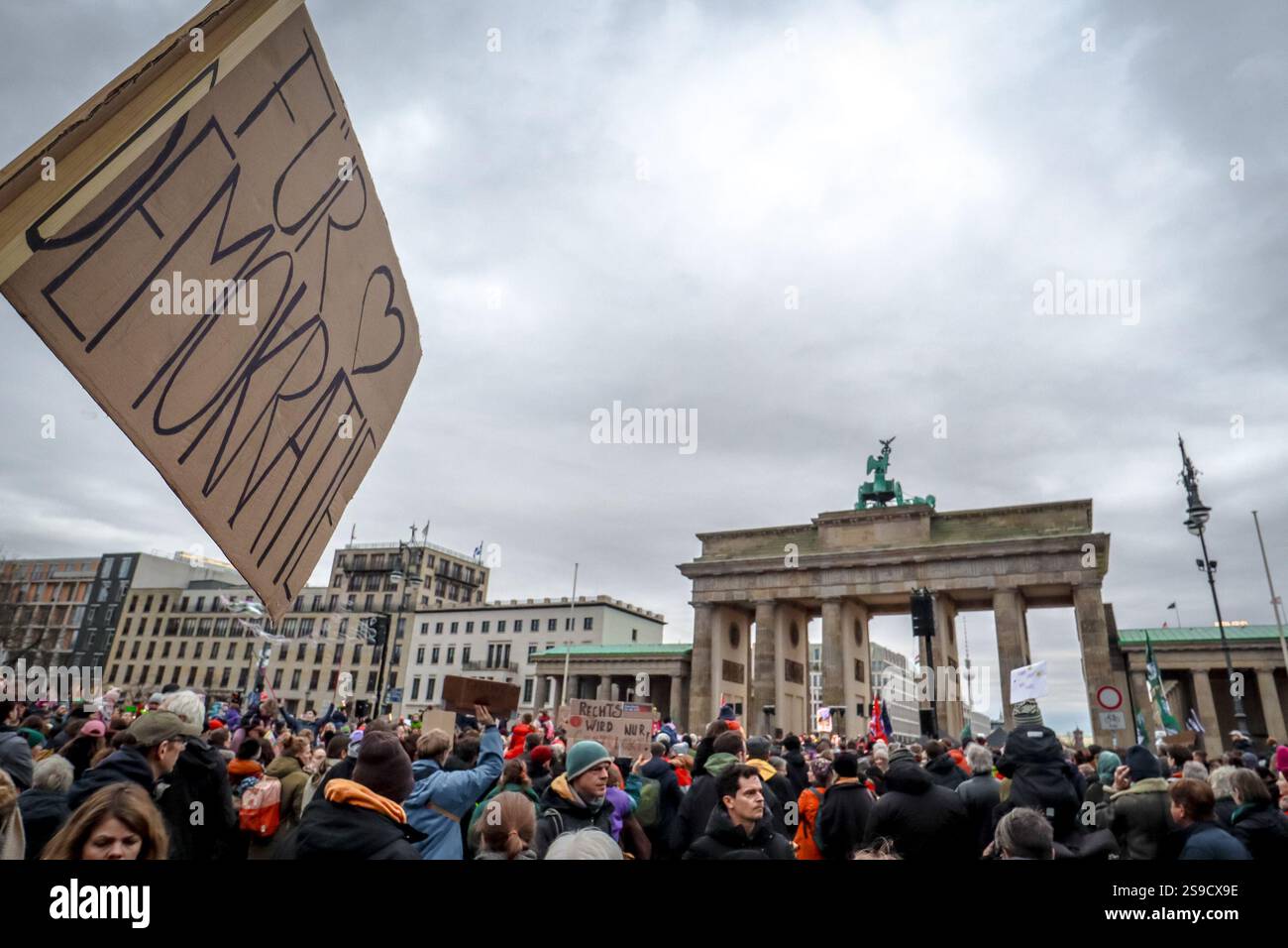 Protesta anti-AfD a Berlino, Germania: Il manifestante ha un cartello con la scritta "für Demokratie" (tedesco: "Per la democraia") davanti alla porta di Brandeburgo. Foto Stock