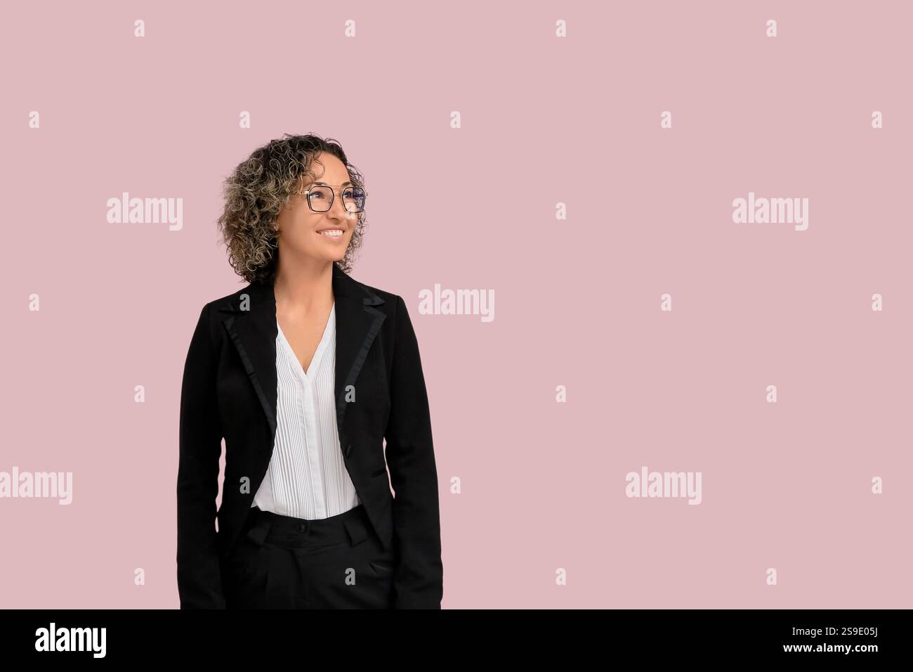 Donna d'affari matura con occhiali da vista su sfondo rosa Foto Stock