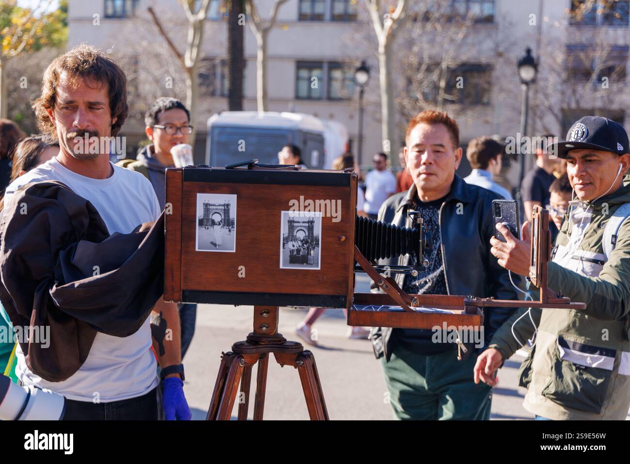 Barcellona - Spagna, 25 gennaio 2025: Un fotografo d'antiquariato utilizza una fotocamera classica per immortalare il vivace festival del Capodanno cinese di Barcellona. Foto Stock