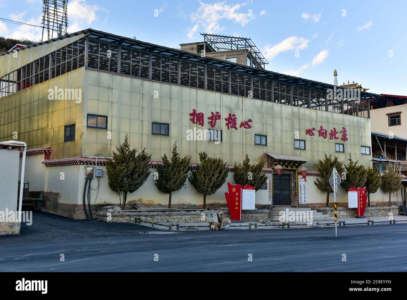 Edificio del Comitato del Partito Comunista Cinese del Villaggio della Liberazione, Shangri-la. Scrivendo sulla facciata "sostenere il centro, cuori verso Pechino" Foto Stock