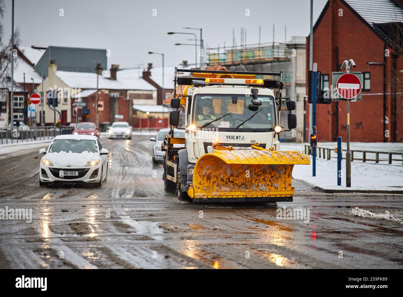 Spazzaneve e gritter, noti anche come levigatrice, spandiconcime saline o camion salino che lavorano ad Ashton-under-Lyne Foto Stock