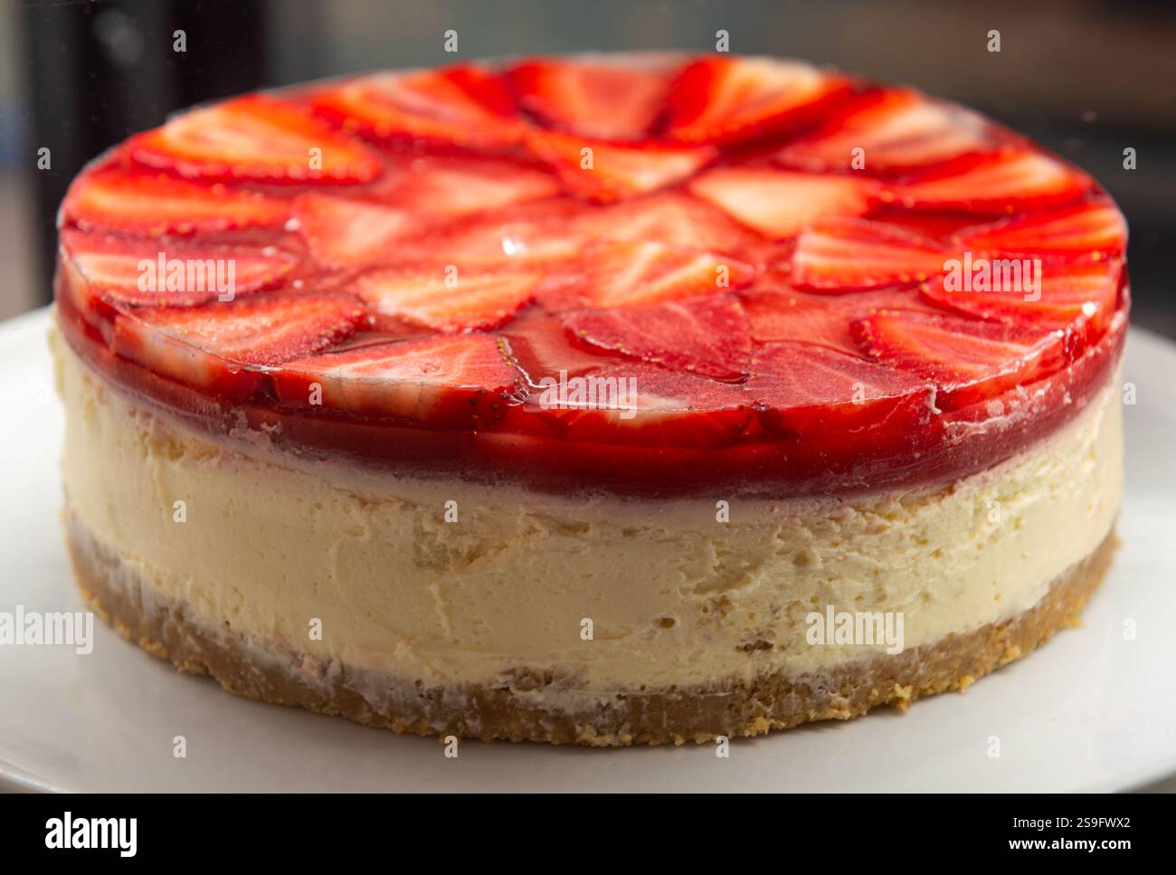 Vivace Cheesecake alla fragola, perfetta per blog di cibo e dessert. Questa immagine di brodo mostra una deliziosa cheesecake fatta in casa condita con fre Foto Stock