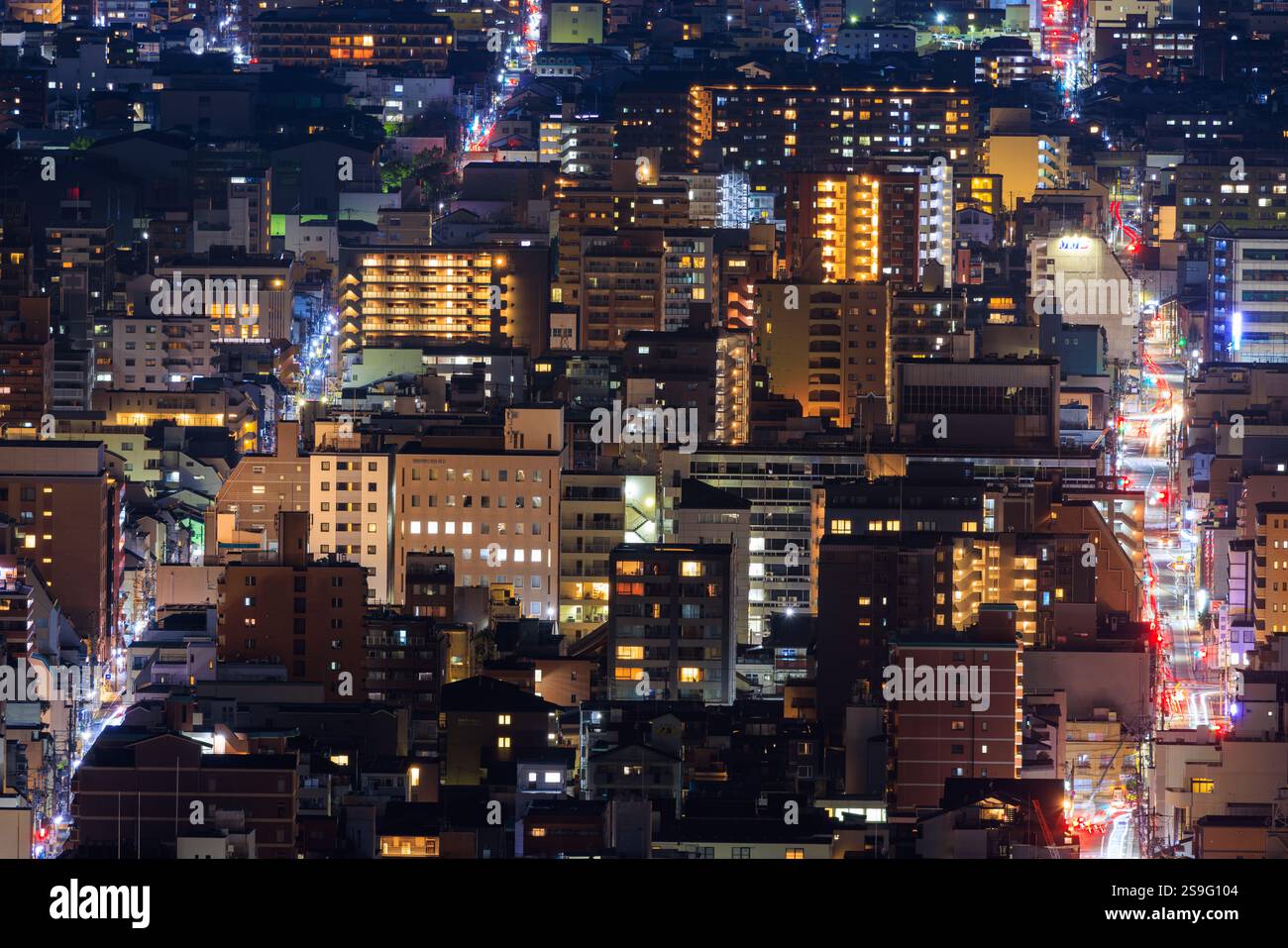 Luci per auto sulle strade trafficate vicino alle torri degli appartamenti in città di notte Foto Stock
