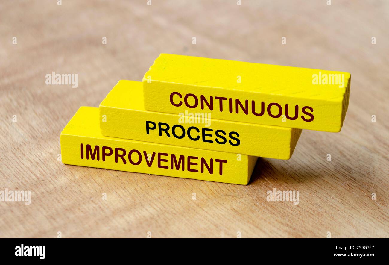 Testo di miglioramento continuo del processo su blocchi di legno gialli. Strategia aziendale e concetto di miglioramento. Foto Stock
