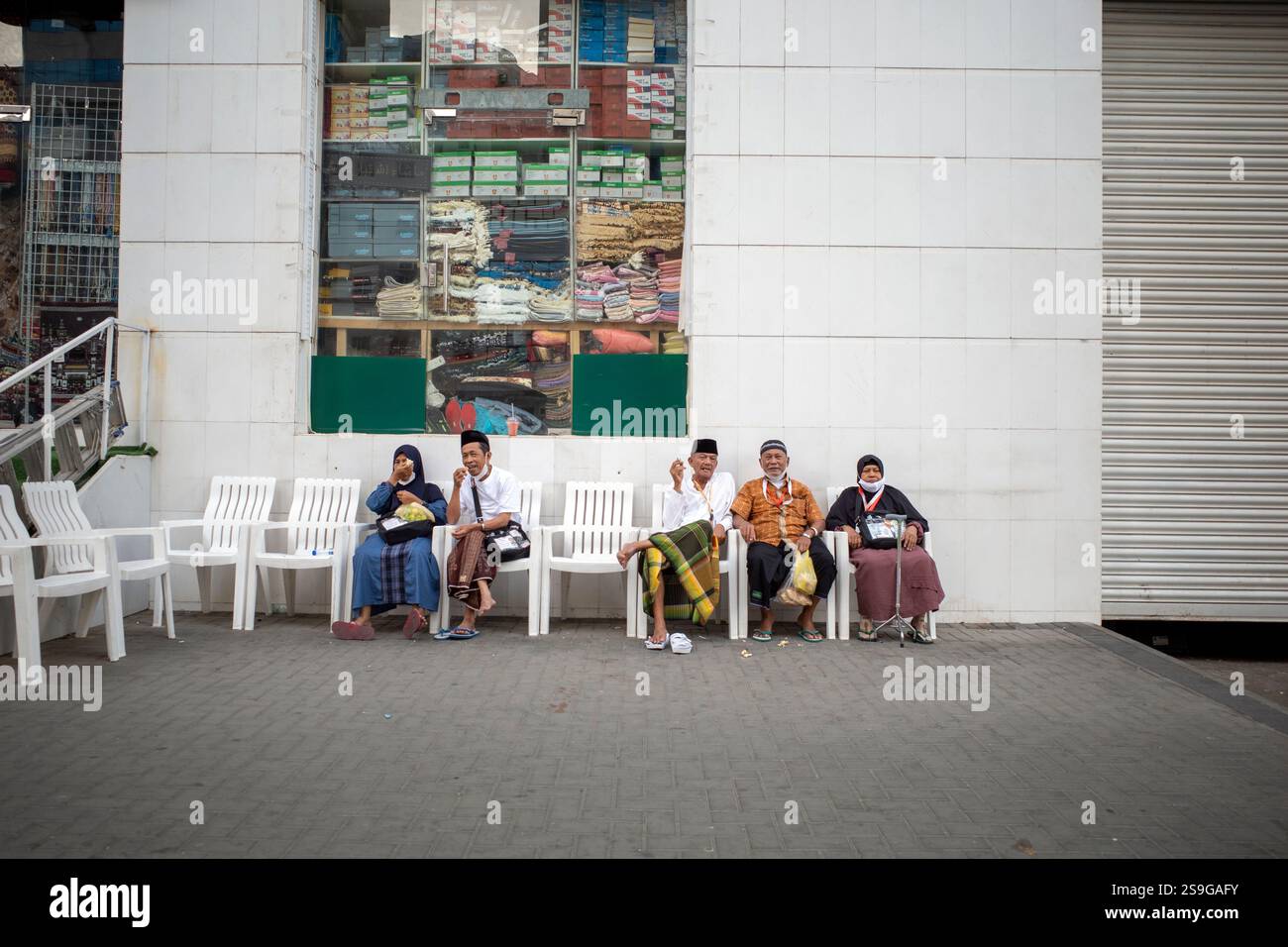 Mecca, Arabia Saudita - 13 giugno 2024: Pellegrini Hajj e Umrah dall'Indonesia seduti di fronte a un hotel a Mecca, Arabia Saudita. Hajj 2024. Foto Stock