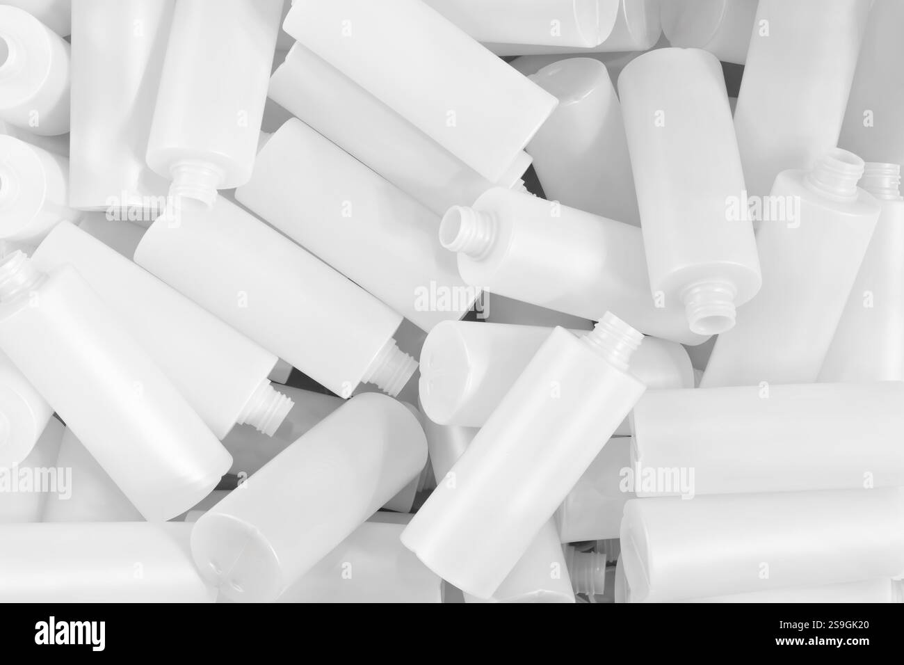 Una pila di bottiglie di plastica bianche con le parti superiori rimosse come sfondo testurizzato. Background del concetto industriale. Foto Stock