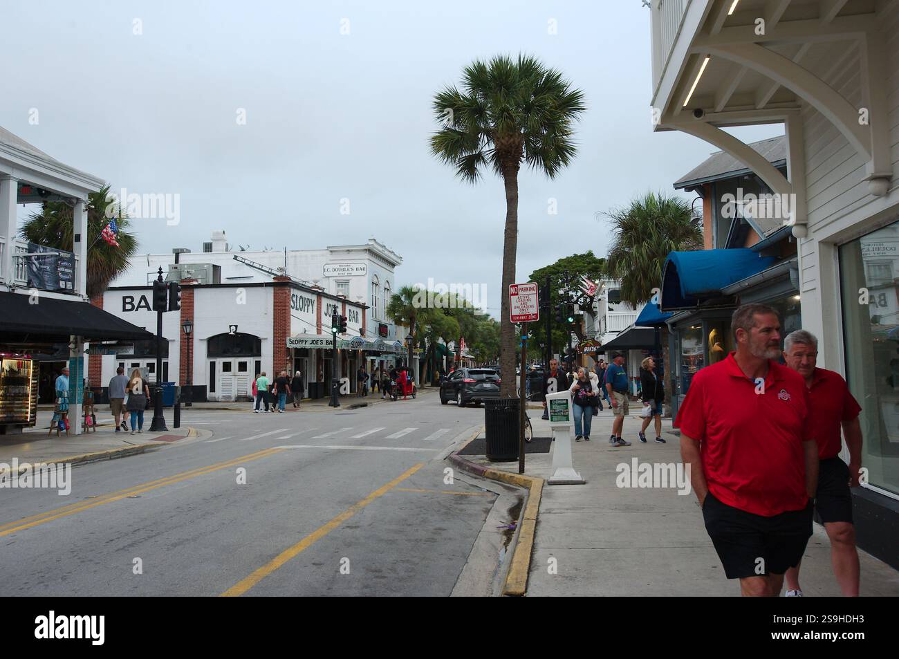 Vista su Duval Street verso lo Sloppy Joe's Bar. Persone in camicia rossa che camminano per strada. Palme sullo sfondo. Solo per uso editoriale Januar Foto Stock