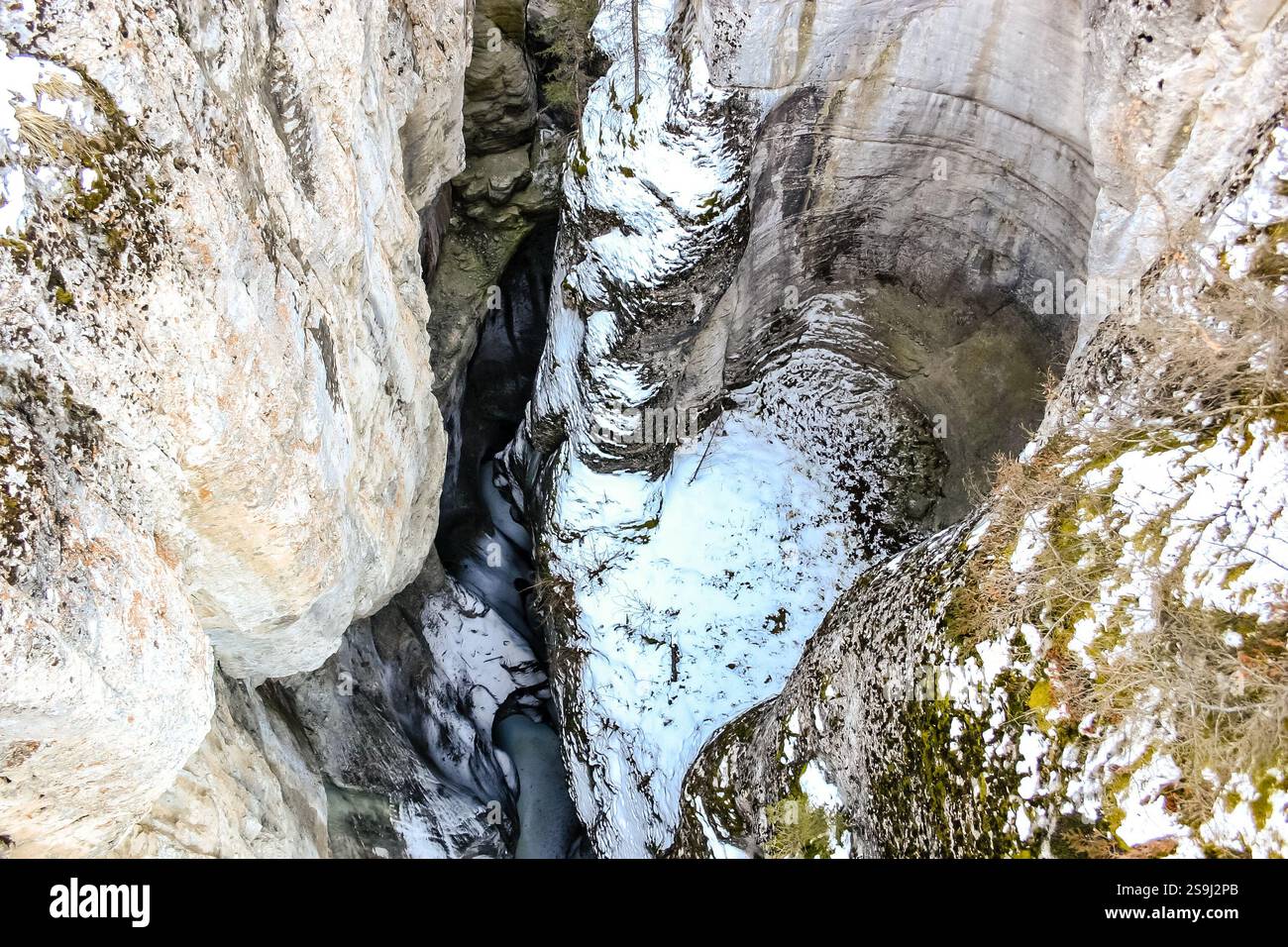 Una grande formazione rocciosa con un buco coperto di neve al centro. Il buco ha la forma di un cuore Foto Stock