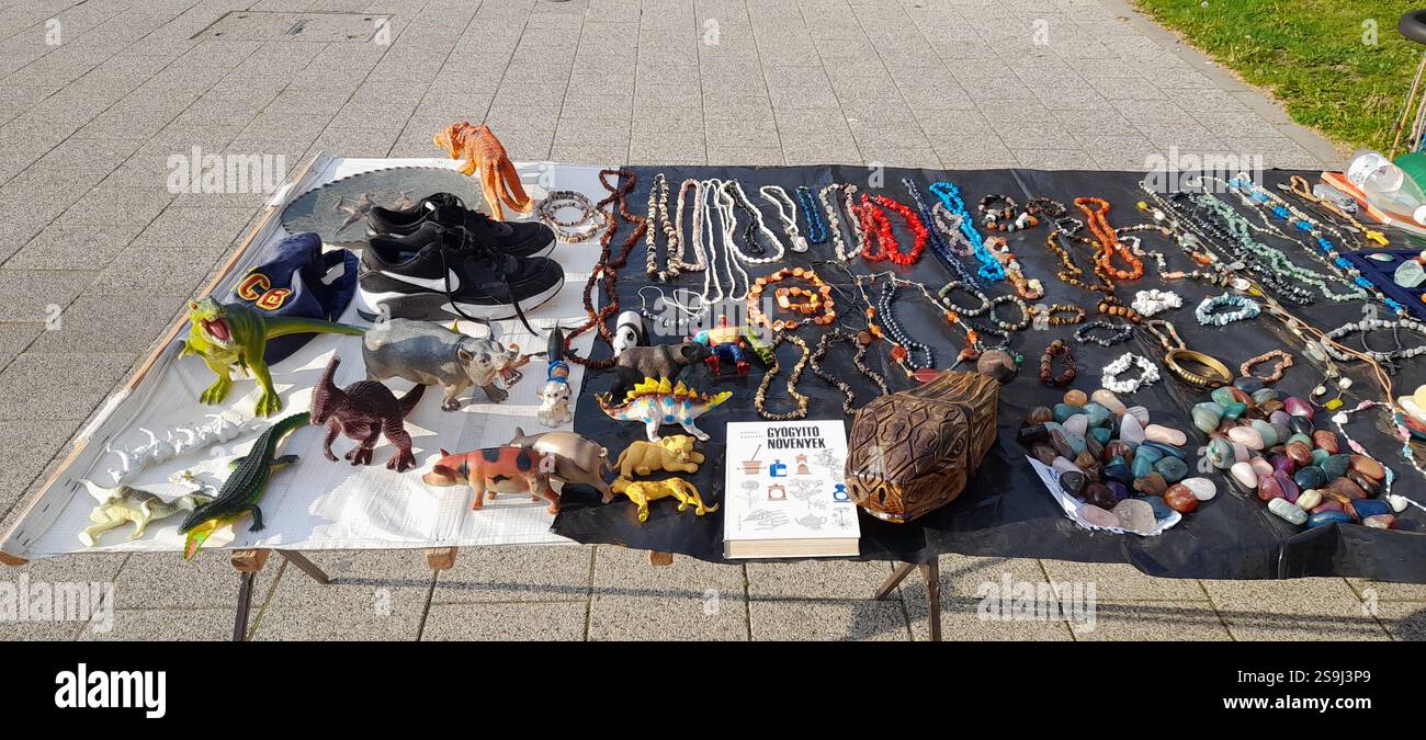 Mercato dell'antiquariato europeo, stand al mercato delle pulci: Pietre umili di cristallo colorate, gioielli di cristallo, collane color ambra, giocattoli vintage, libri vintage, perline di rosario vintage , collane in pietra naturale e minerali, ciondoli in pietra preziosa, guanti in pelle vintage, bigiotteria vintage, croce in pietra vintage ( pietre minerali pietre semi-preziose ), bracciali in ottone, bracciali in cristallo, fossili, agata, pietre umili al quarzo rosa, giocattoli di maiale vintage, giocattolo T-rex vintage, enorme tartaruga di legno intagliata a mano / testa di tartaruga Foto Stock