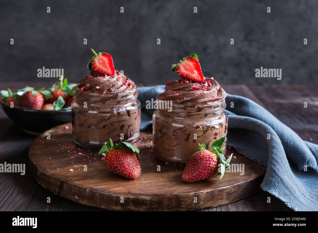 Deliziosa mousse al cioccolato ricoperta di fragole fresche e liofilizzate in vasetti di vetro Foto Stock