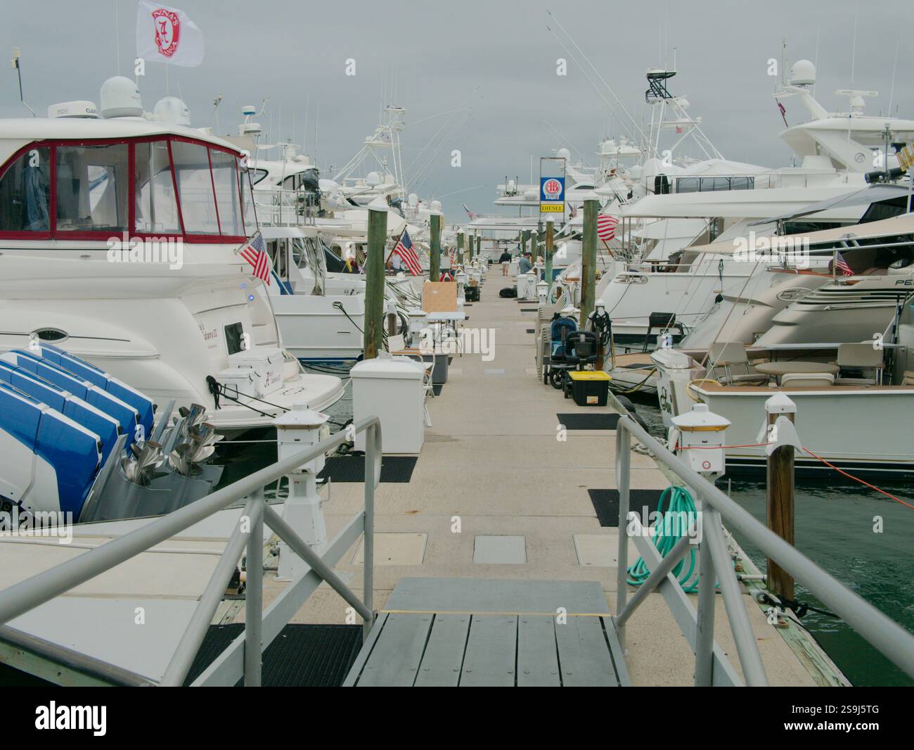 Ampia visuale POV che conduce lungo una rampa di accesso in metallo per barche fino all'attracco delle barche in cemento con più barche a sinistra e a destra. Solo per uso editoriale a gennaio Foto Stock