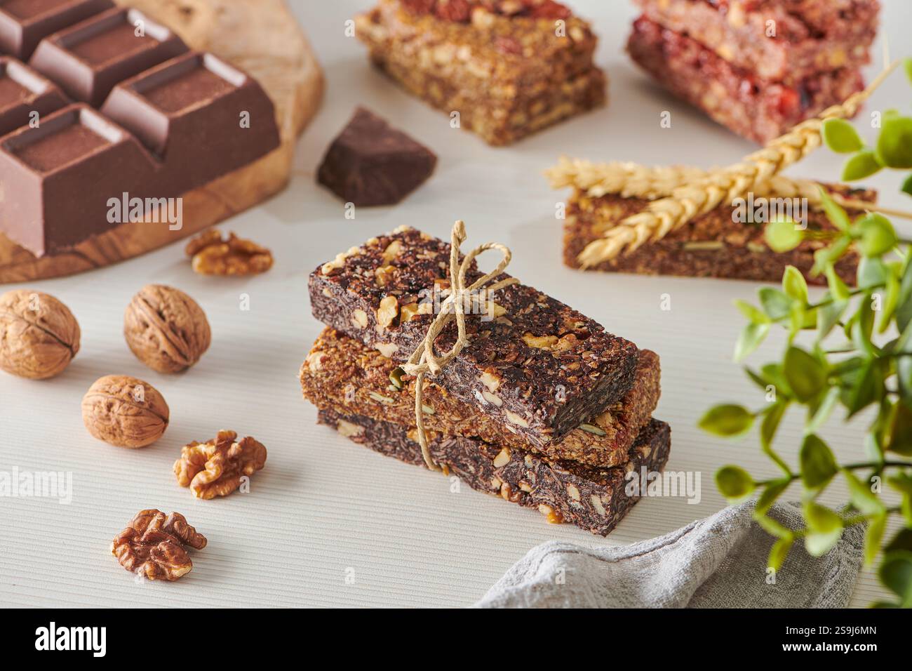 Barrette energetiche con cioccolato e mescolare le noci su un tavolo bianco. Noci, arachidi, pecan, mandorle, anacardi, pistacchio Foto Stock
