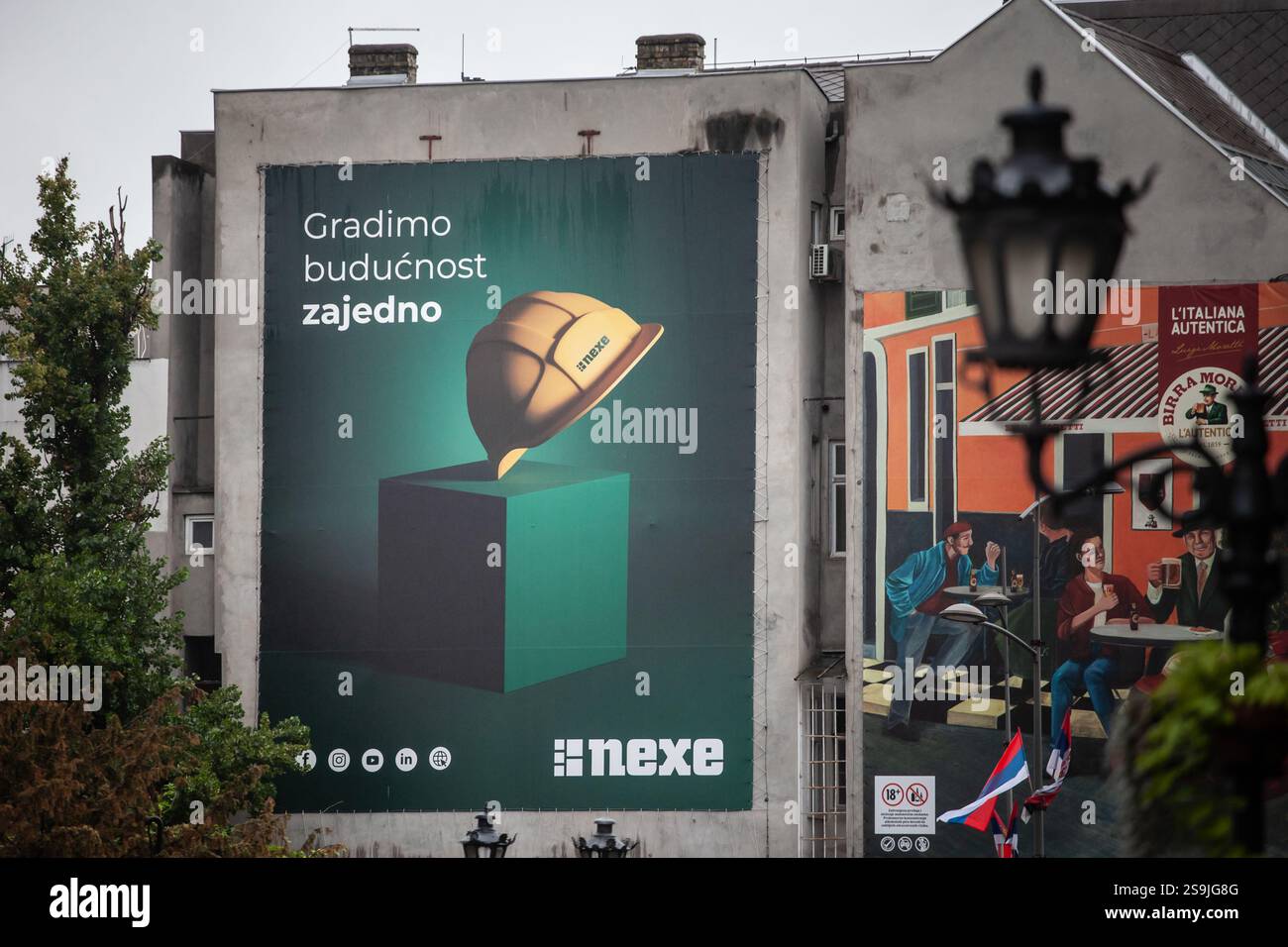 NOVI SAD, SERBIA - 1 LUGLIO 2024: Un grande cartellone pubblicitario a Novi Sad presenta il logo del gruppo Nexe, promuovendo i materiali da costruzione e l'edilizia Foto Stock