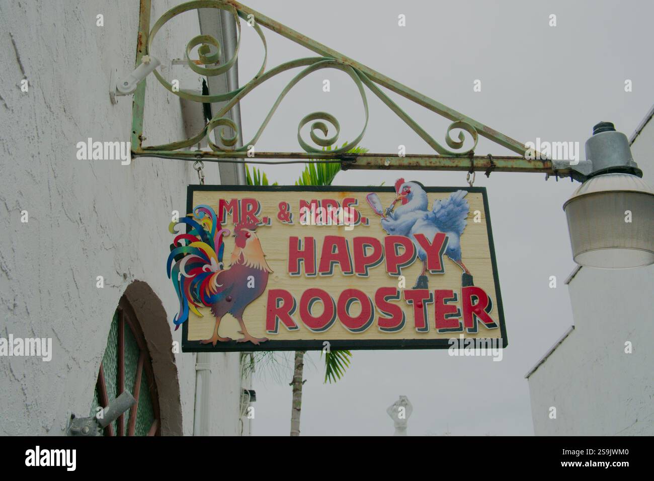 Uso editoriale solo 20 gennaio 2025 Key West, Florida, USA. Happy Rooster Gifts & More Store, insegna appesa a un palo in metallo decorato. Foto Stock