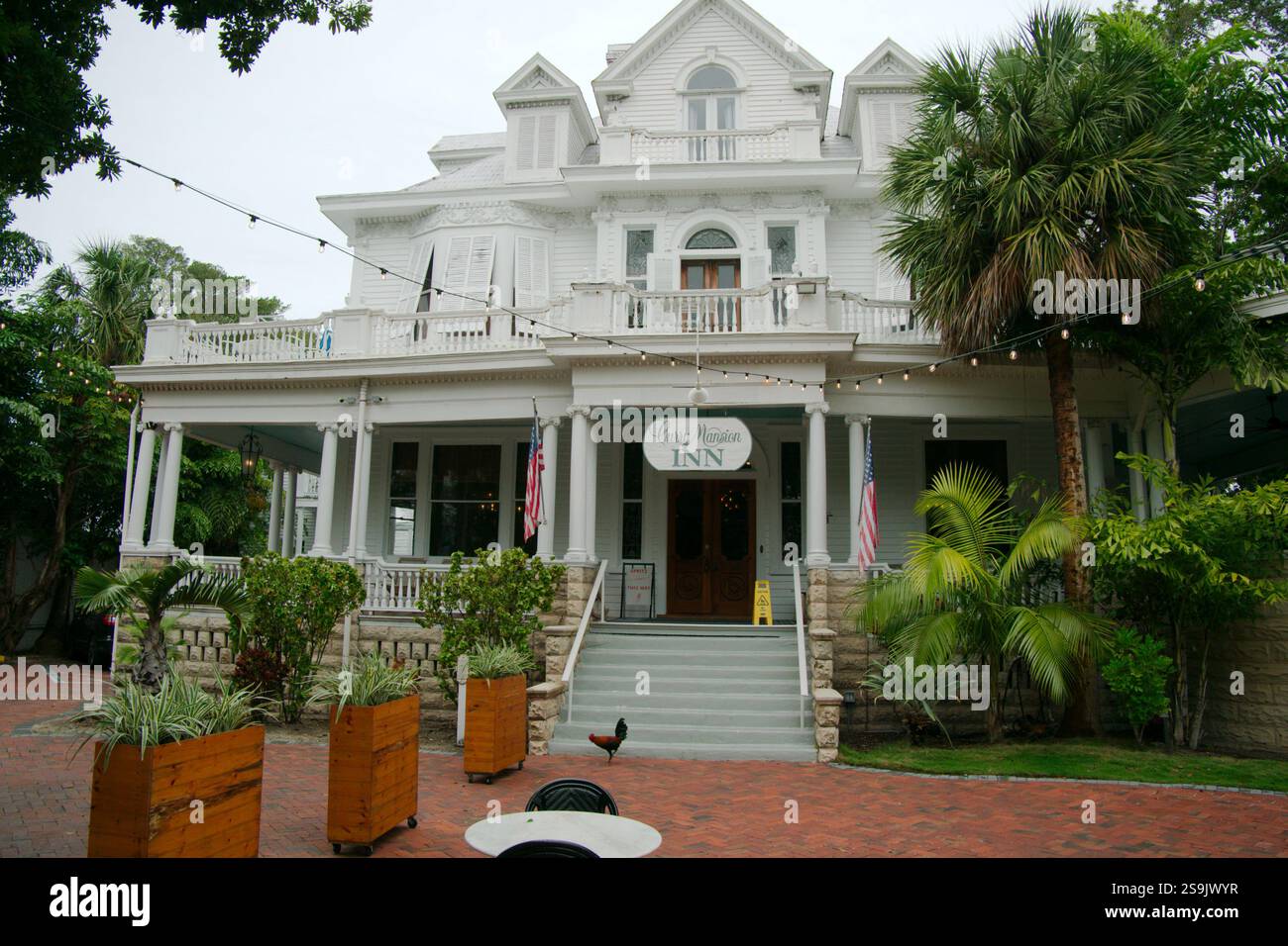 Uso editoriale solo 20 gennaio 2025 Key West, Florida, USA. CURRY MANSION INN Vista sul vialetto di mattoni rossi fino alle colonne sul portico anteriore e sui mu Foto Stock