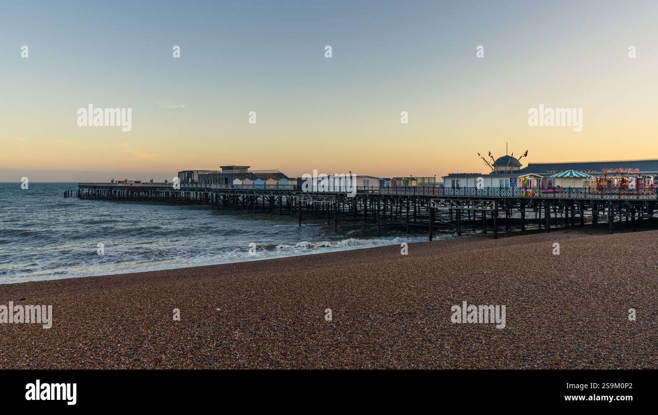 Hastings, East Sussex, Inghilterra, Regno Unito - 11 maggio 2022: Atmosfera serale sulla spiaggia, con il molo sullo sfondo Foto Stock