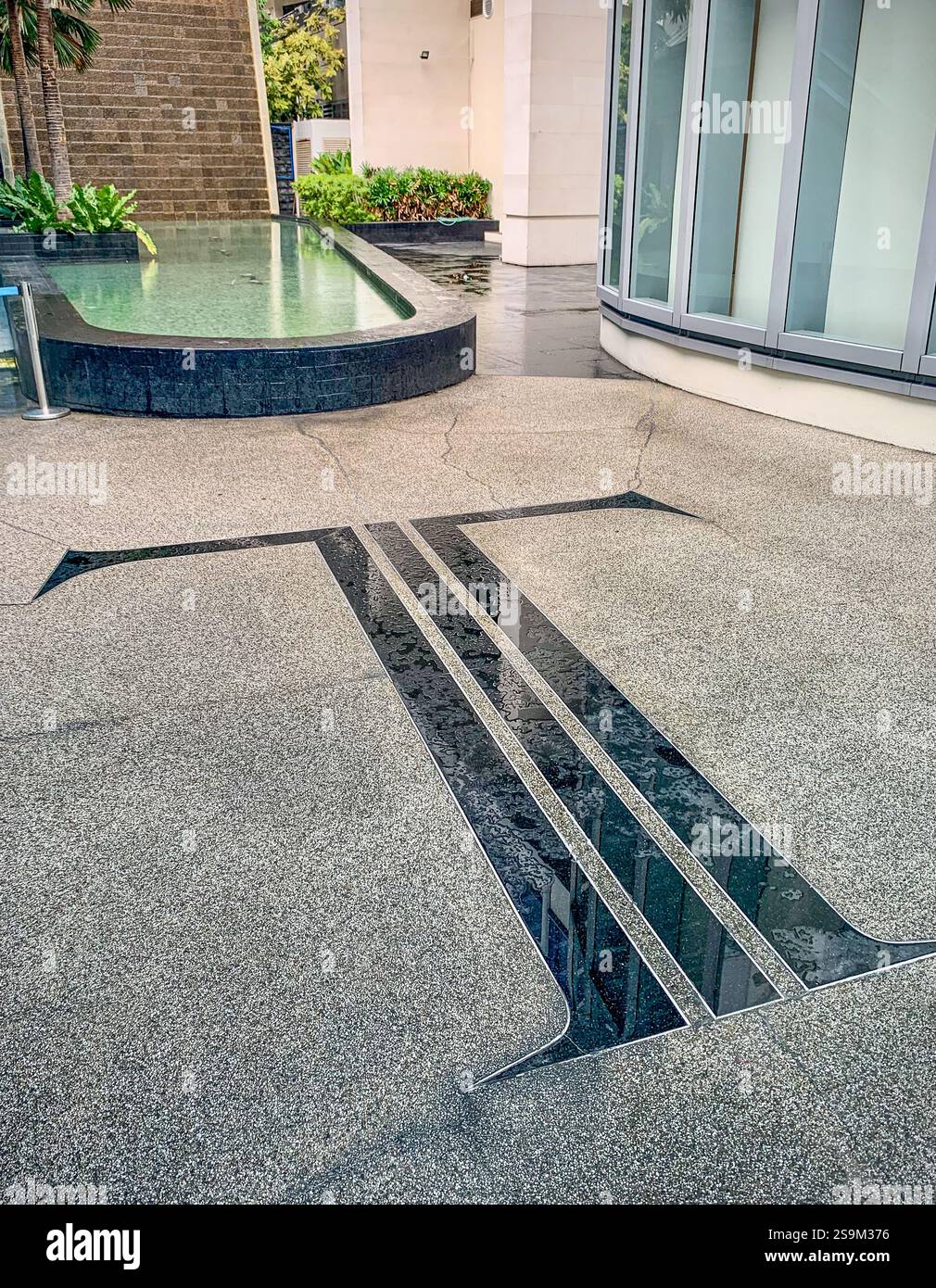 Lettera T in marmo incorporata nel pavimento, ingresso alla Trump Tower, grattacielo del centro finanziario Makati, centro affari filippino, alto edificio, Metro Manila - Immagine stock catturata con smartphone