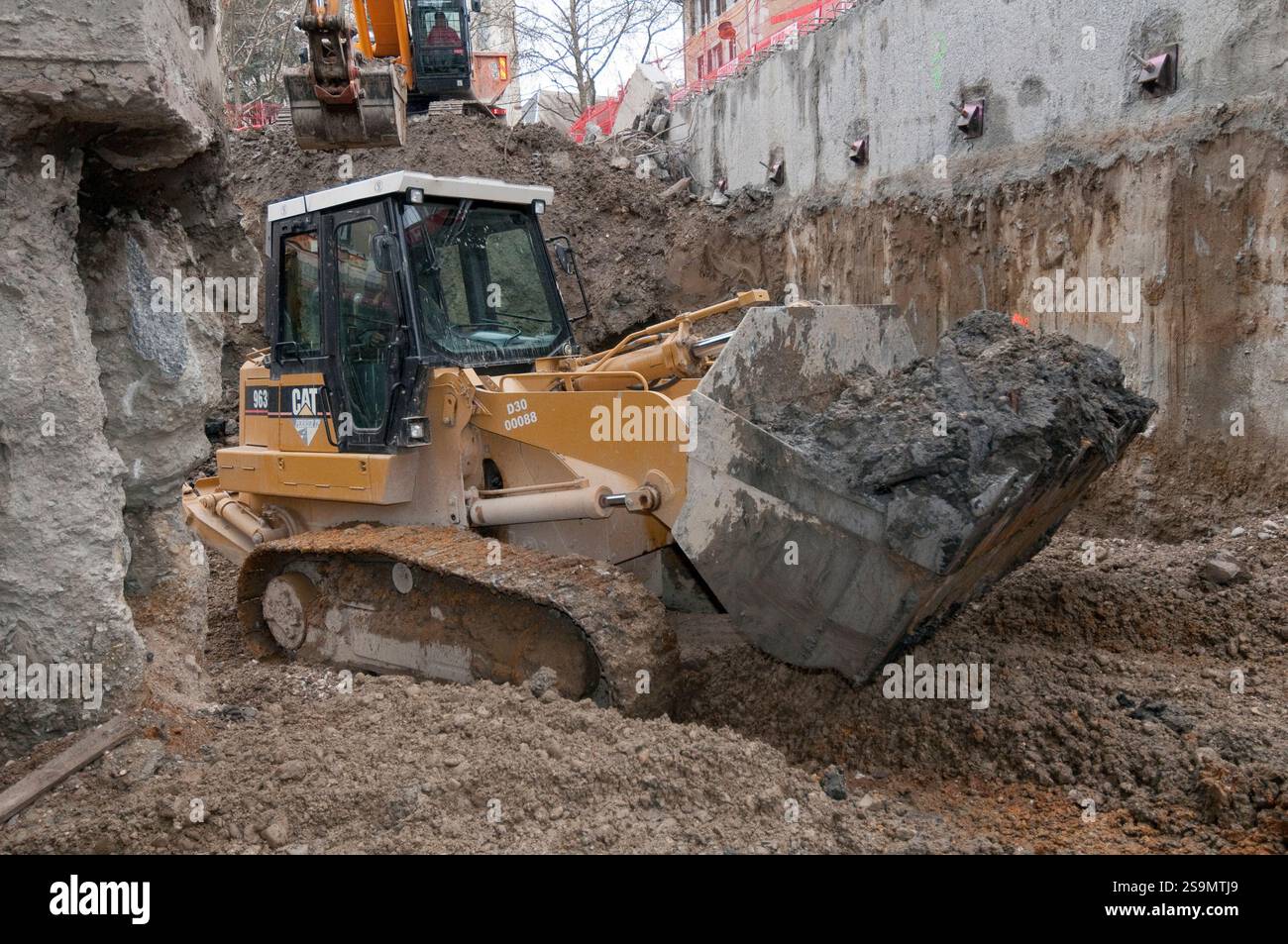 Lavori di terra. Pale cingolate CAT 963 in azione benna riempita di terra. Foto Stock